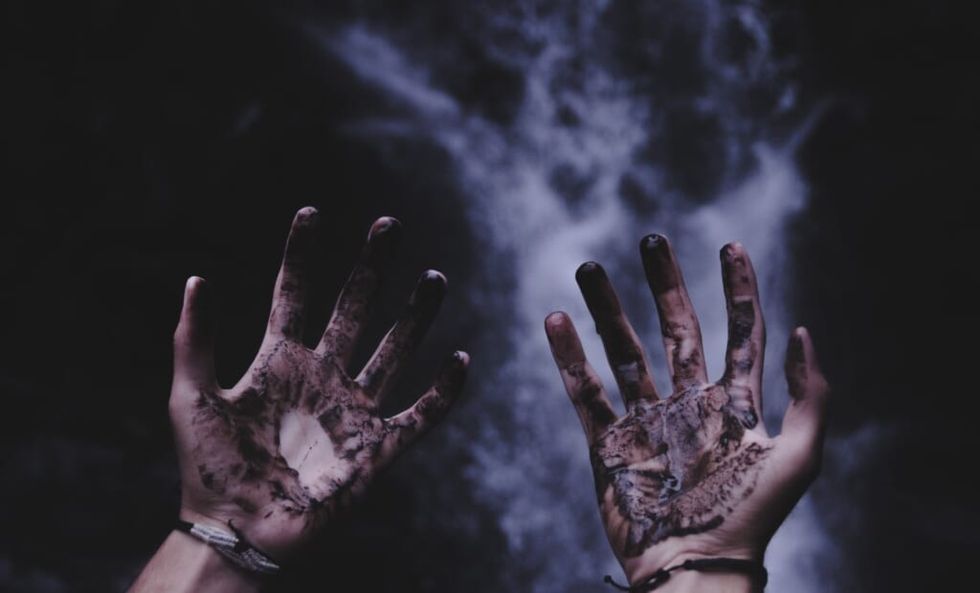 blood covered hands with smoky background
