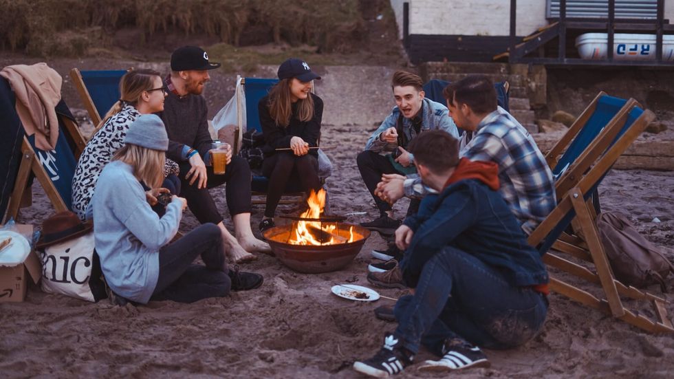 people sitting around a bonfire 