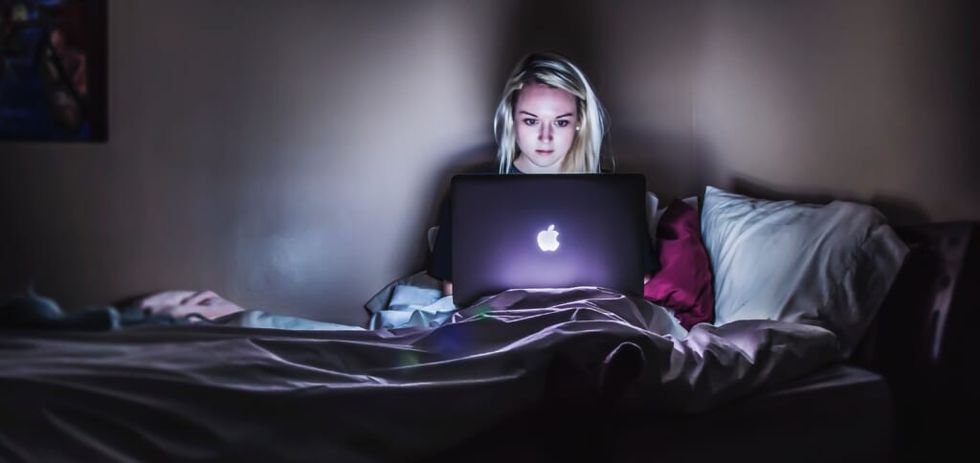 stressed out young woman on laptop in the dark