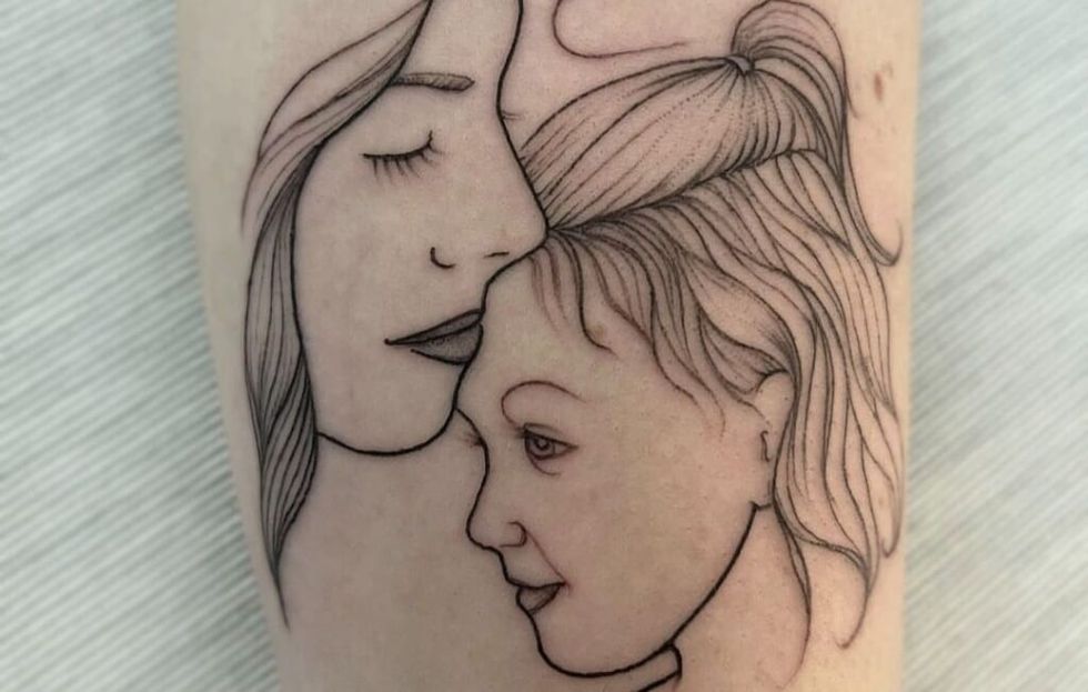 mom and daughter cartoon tattoo on arm