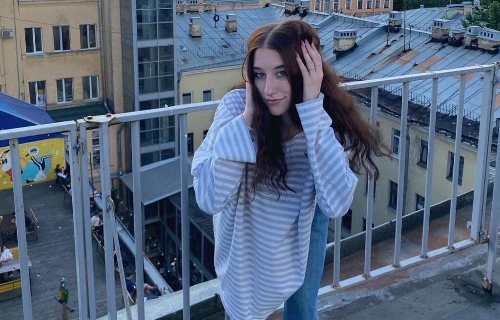 young woman poses on balcony
