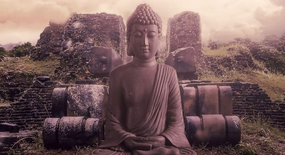 A stone statue of Buddha in meditation pose
