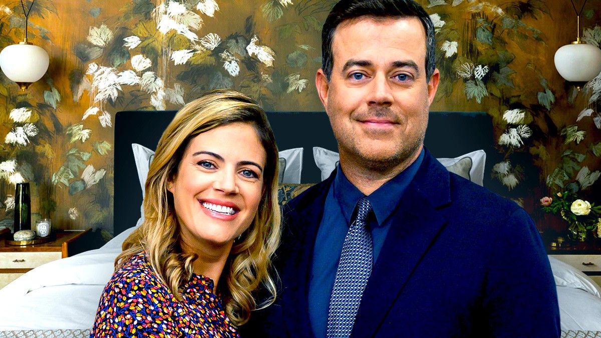 Carson Daly and Siri smiling in front of bed