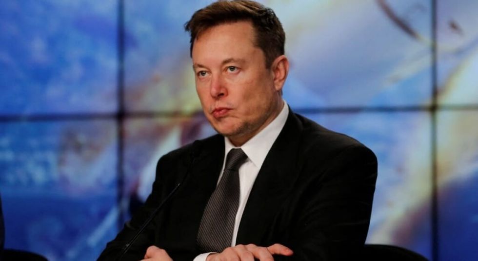 Elon Musk arms crossed during an interview