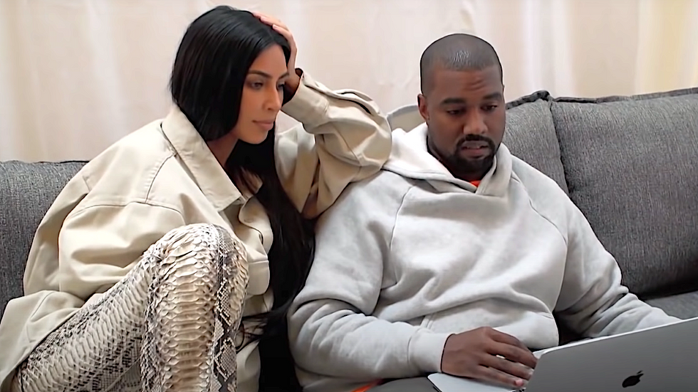 Kanye West and Kim Kardshian on the couch looking at a computer