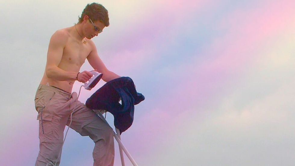 Man irons clothes shirtless
