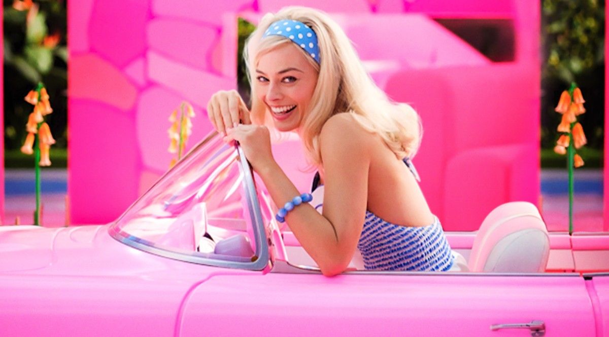 Margot Robbie as Barbie for promotional picture in pink convertible