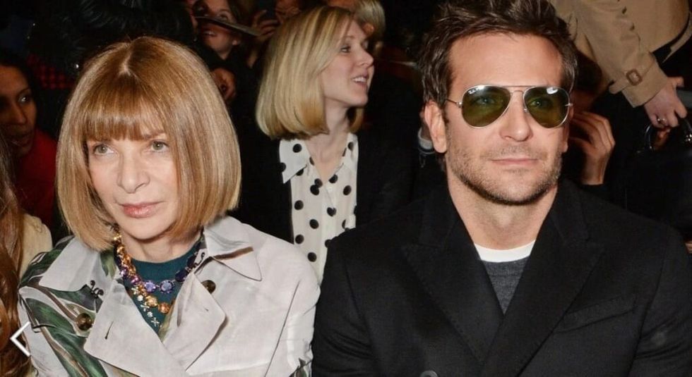 Actor Bradley Cooper and Vogue editor Anna Wintour seated at fashion show.