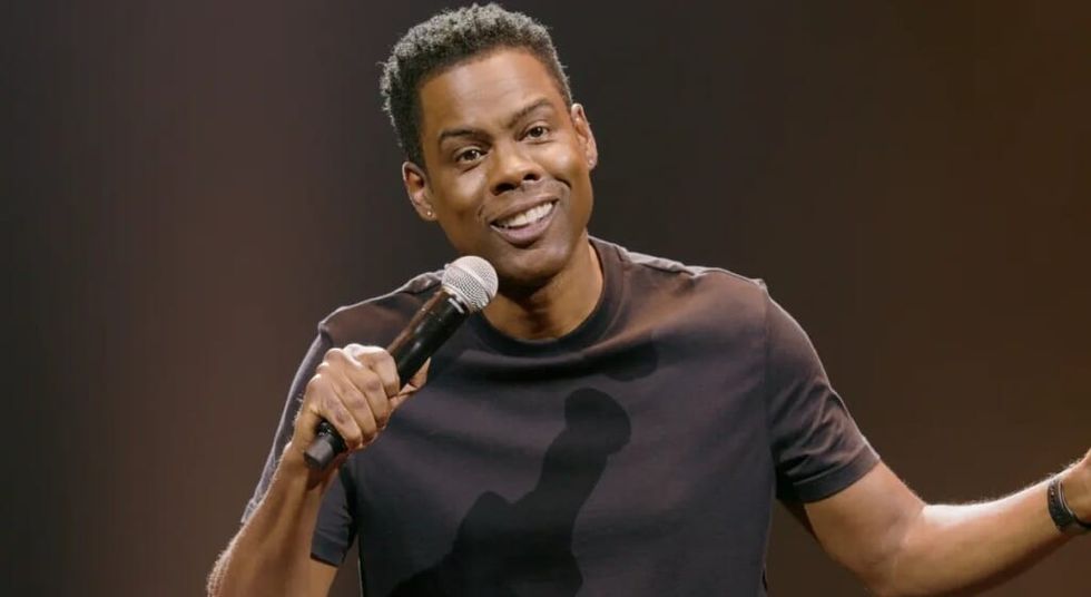 Chris Rock pe scenă într-un tricou negru în timpul rutinei sale de stand-up