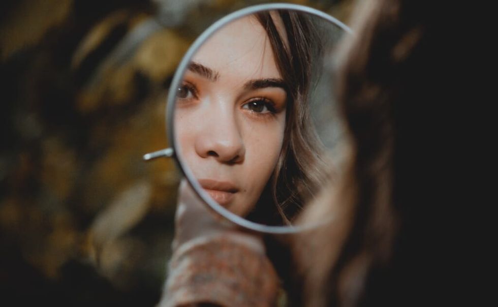 young woman looking in mirror