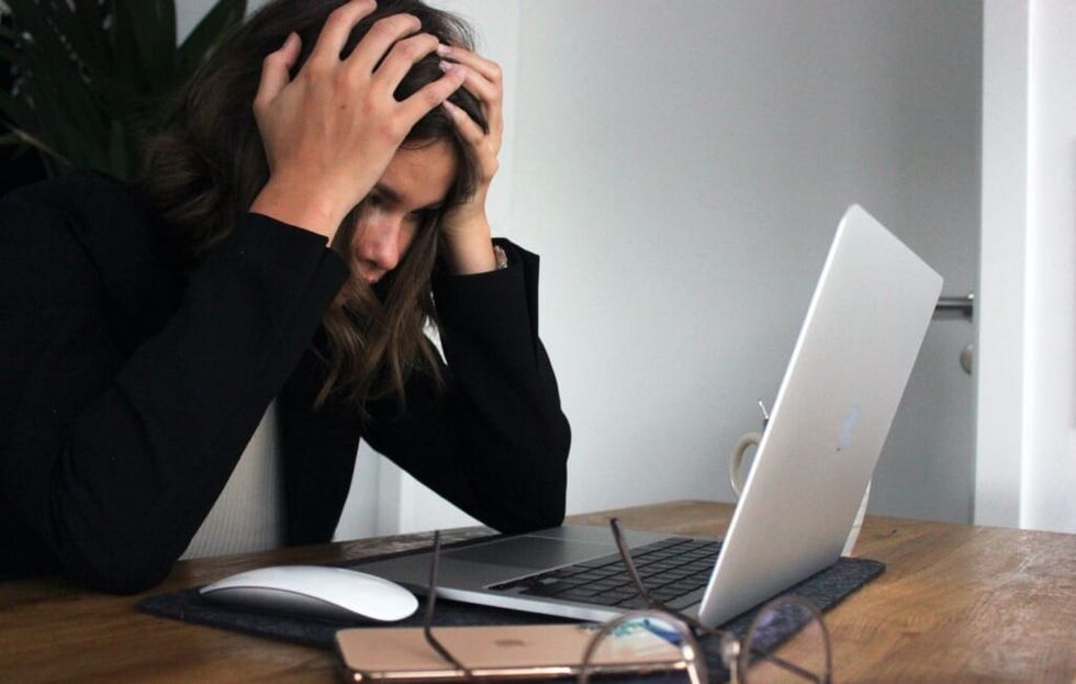 young woman is stressed in front of laptop
