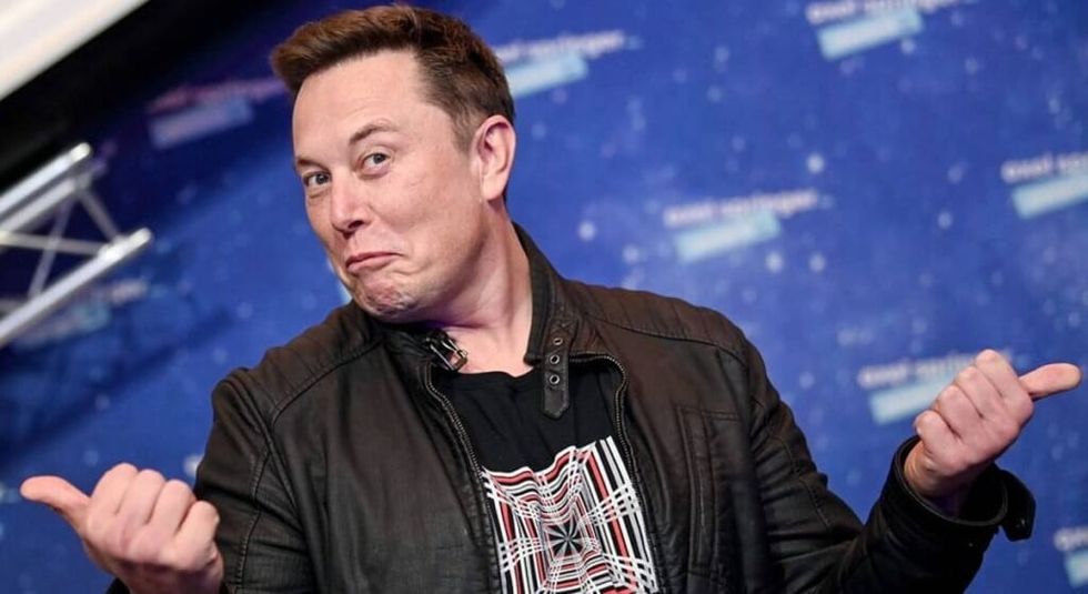 Elon Musk arată cu degetul în sus când partajează o conversație.