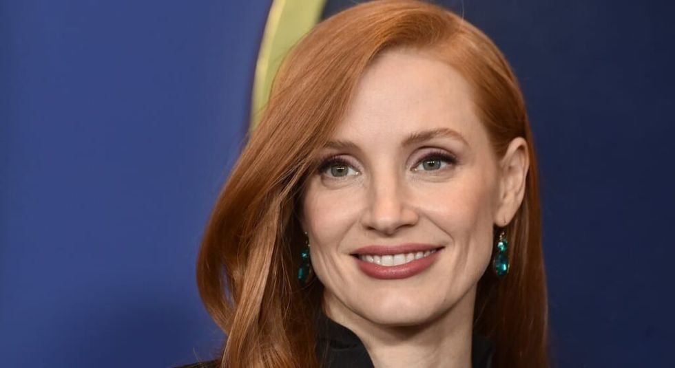 Jessica Chastain red hair brushed back and she is smiling