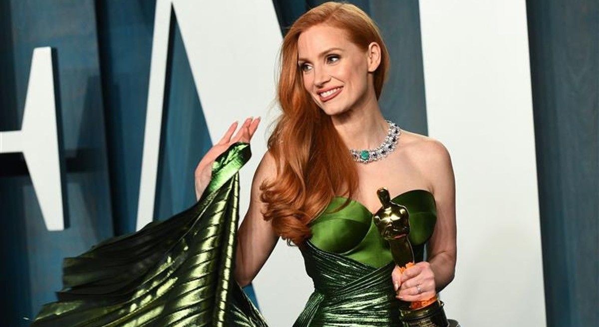 Jessica Chastain in green dress holding an award.