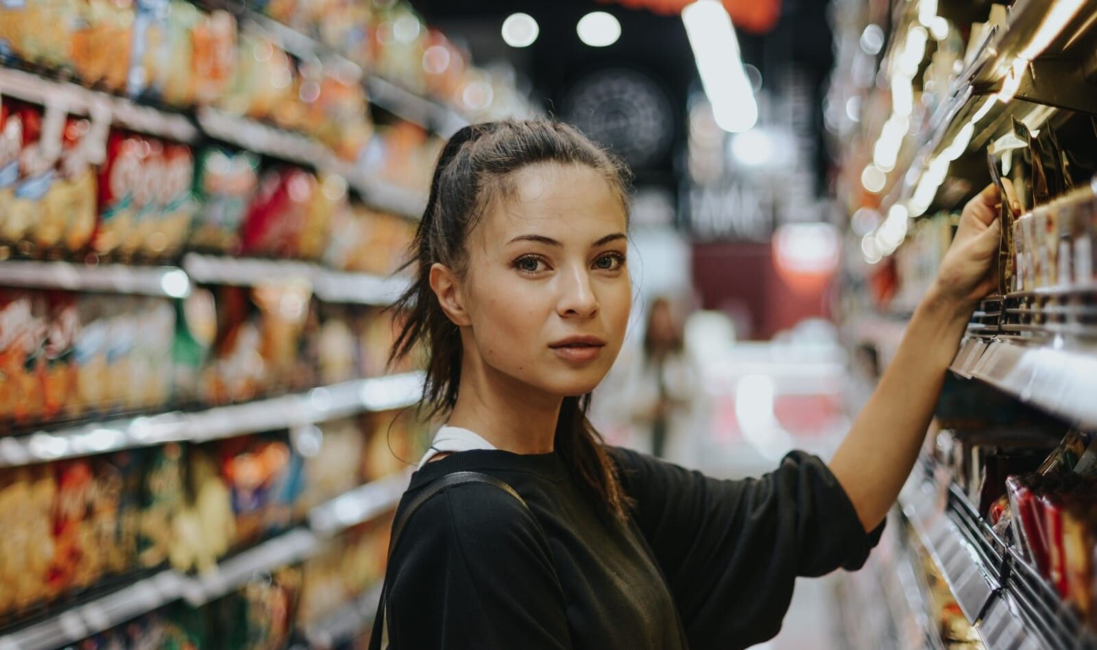 woman grocery shopping looks into lens
