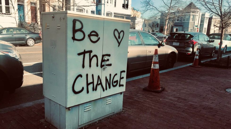 "be the change" written on a structure on the road