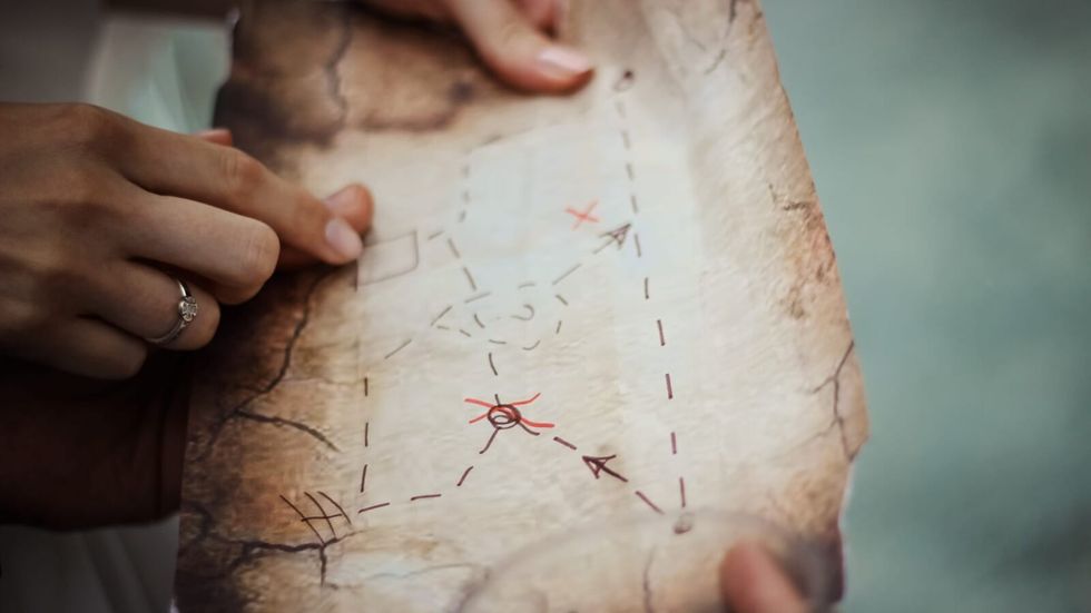 person holding a treasure hunt map