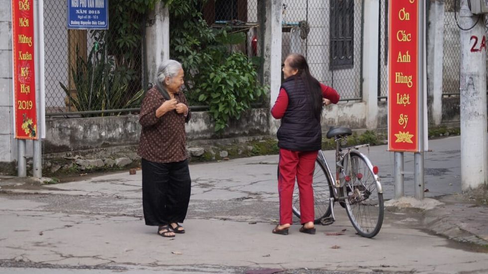 two women speak on the street