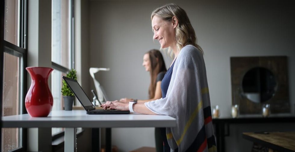 two women sit at desk doing work