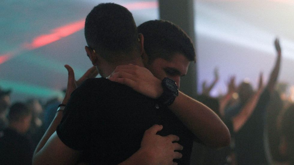 2 men hugging in a crowded room