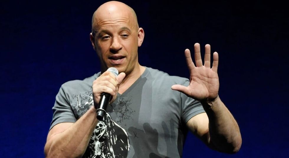 Vin Diesel holding a microphone during an interview.