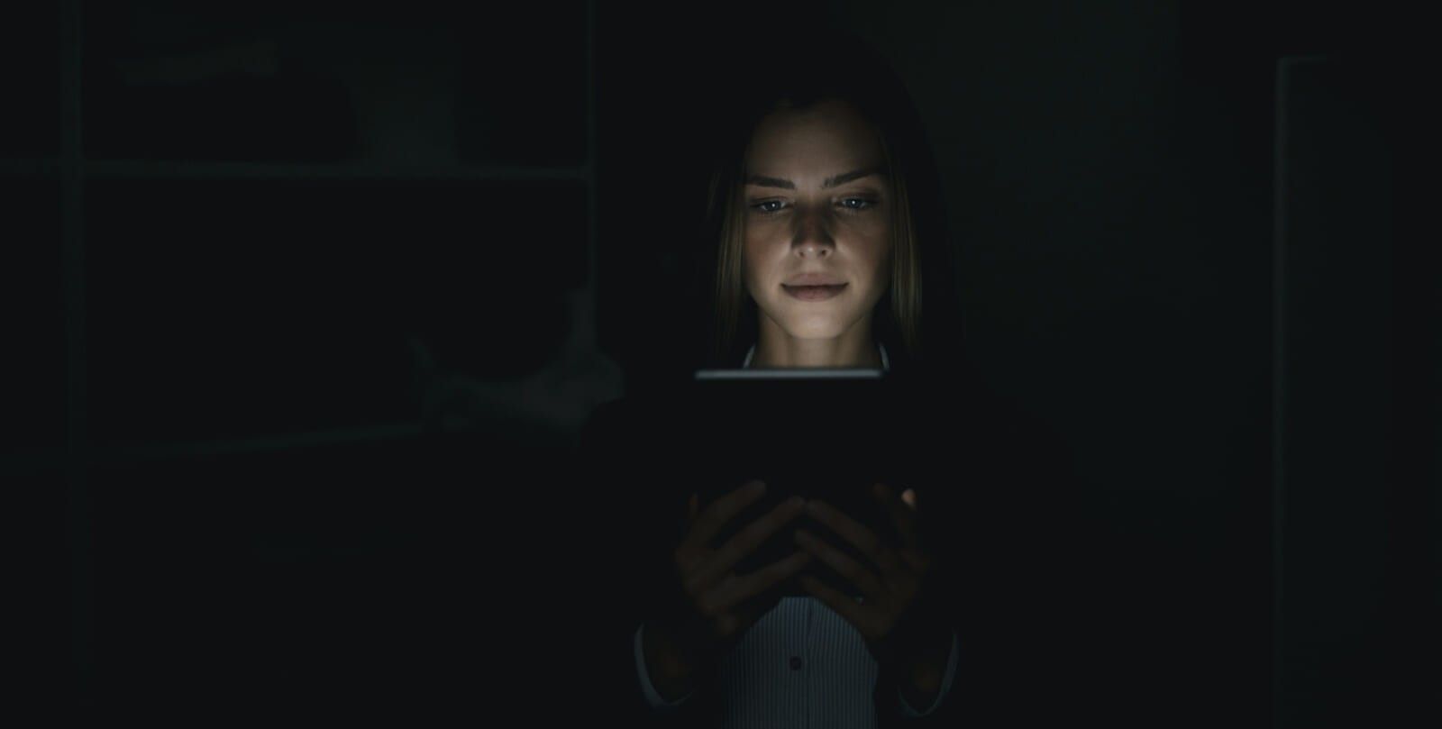 Young woman using digital tablet in he dark