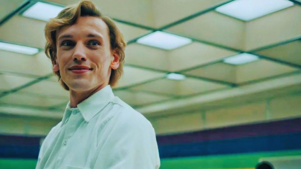 Jamie Campbell Bower dressed all in white in the Rainbow Room on the set of Stranger Things.