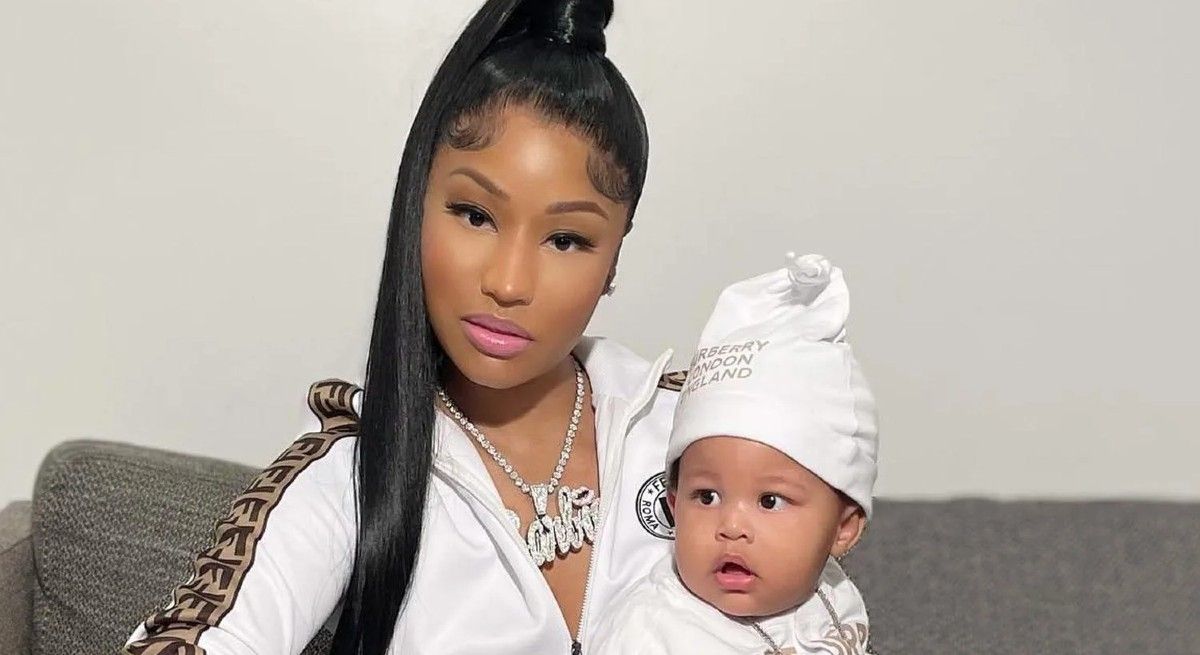 Nicki Minaj dressed in white track suit holding her son.