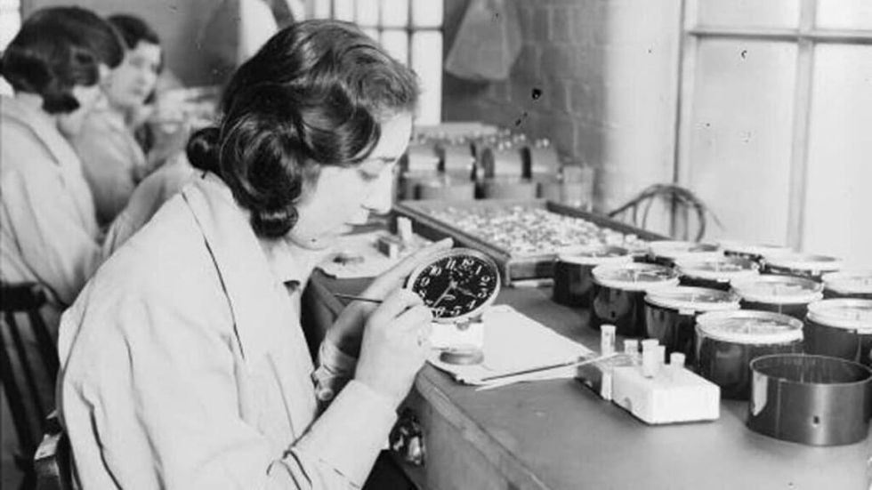 A so-called Radium Girl, coating a clock face with self-luminous paint