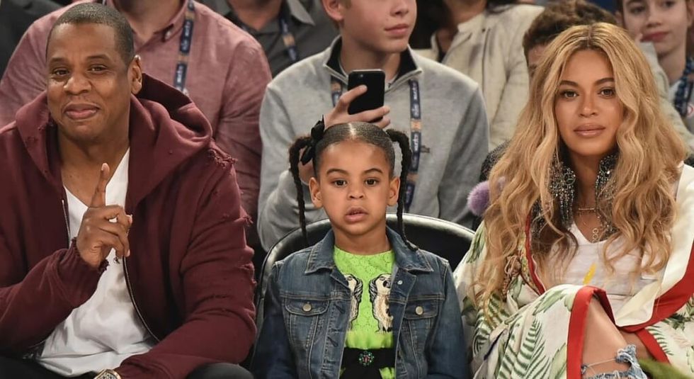 Beyonce, Jazy Z, and daughter Rumi sitting courtside at a basketball game