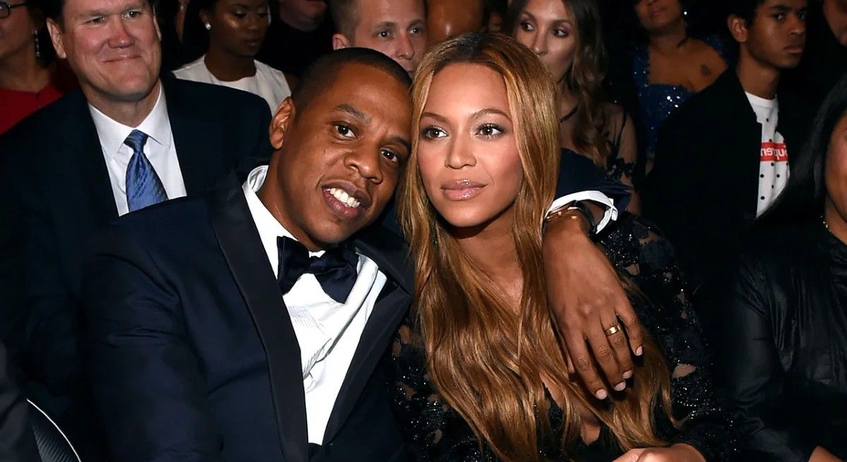 Jay- Z with his arm around Beyonce at awards show.