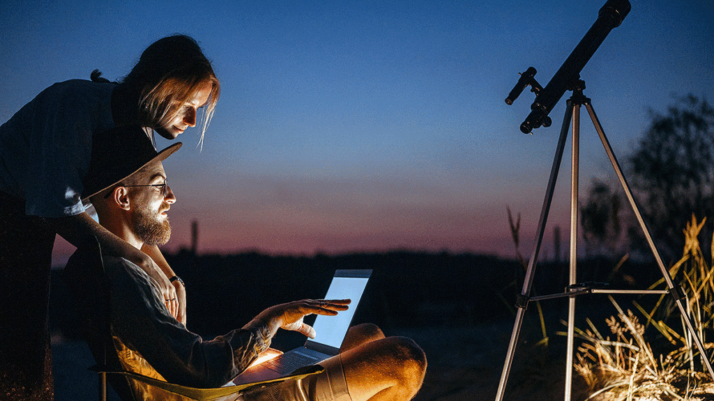 couple stargazing while talking and using a computer