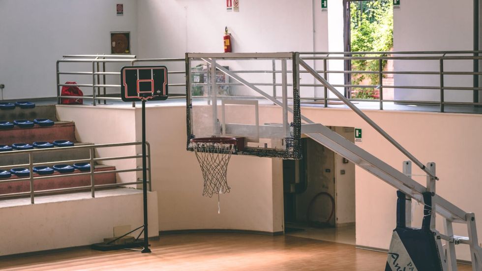 an empty school gym with a basketball court