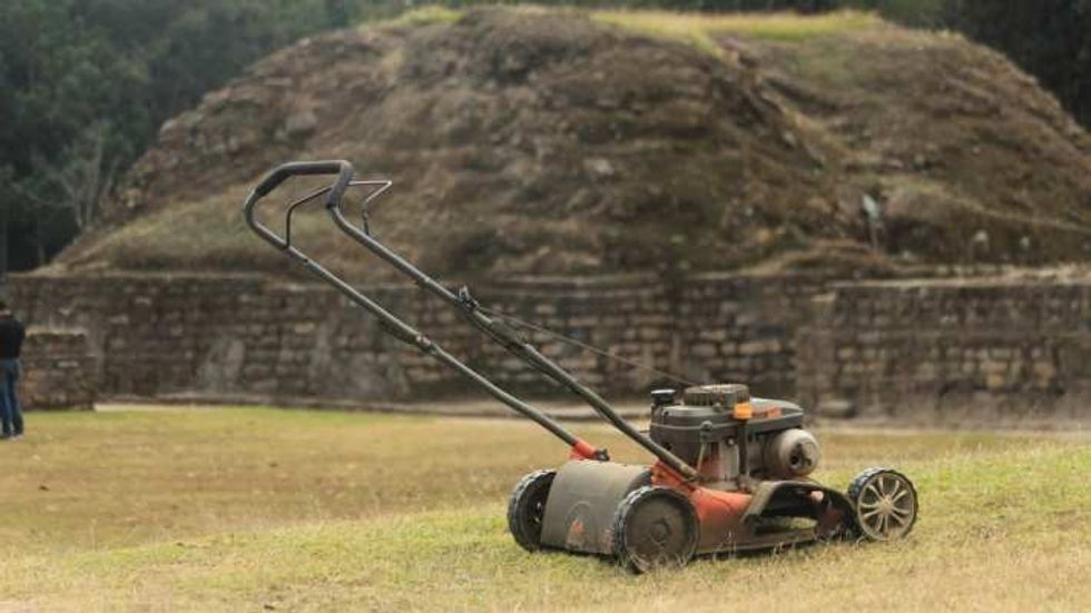 lawn mower in the middle of a green field