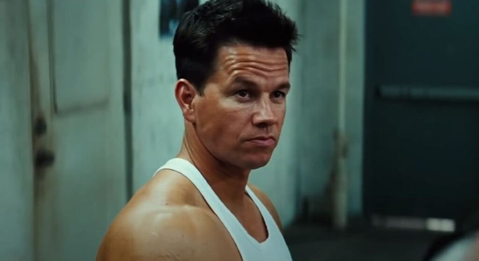 Mark Wahlberg in white tank top looking off camera.