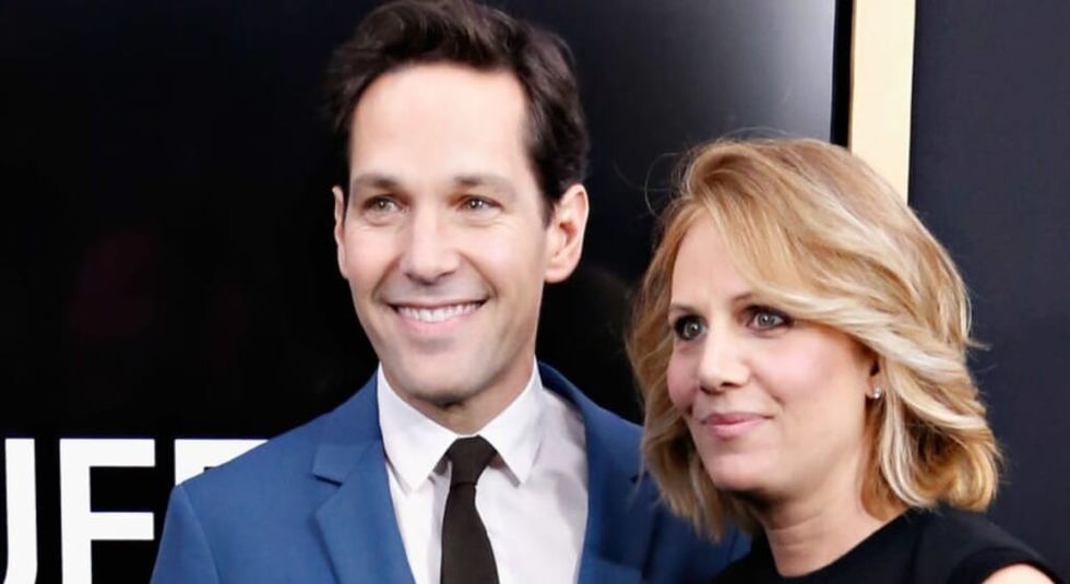 Paul Rudd in blue suit posing with wife Julie Yaegar on the red carpet
