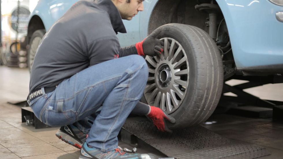man changing a tire on a car