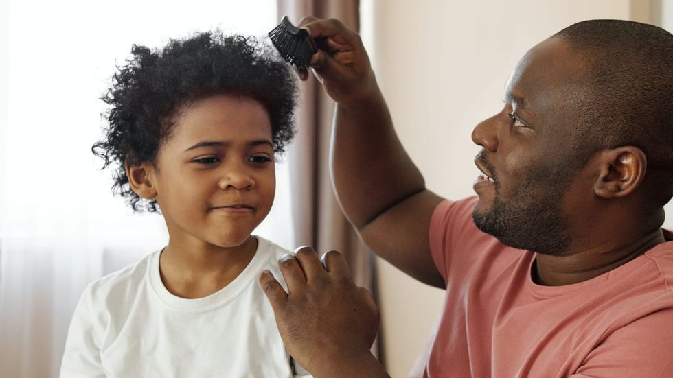 man combing little boy's hair