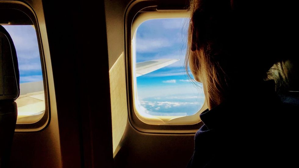 woman looking out of a airplane window