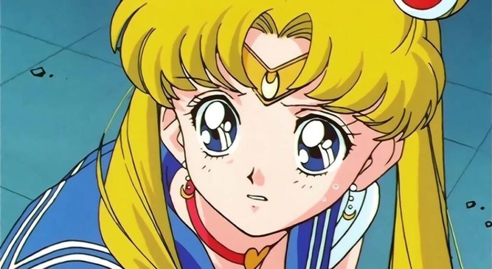 Sailor Moon, blonde hair, looking up with large, sad eyes.