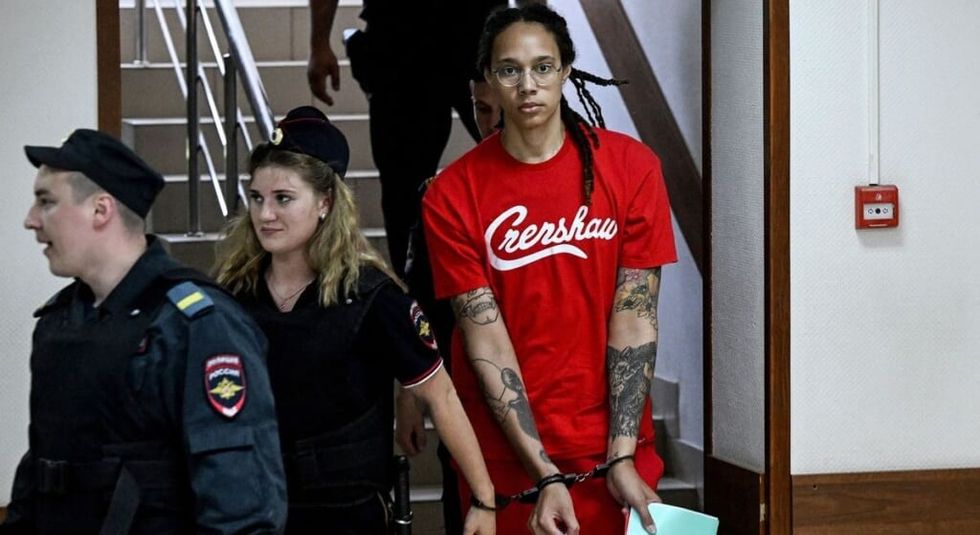 Brittney Griner in handcuffs being led away by Russian police.