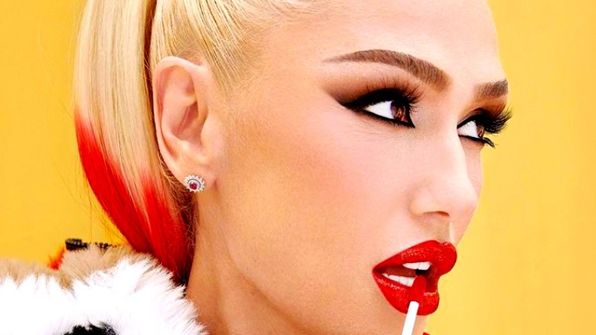 Gwen Stefani putting on red lipstick