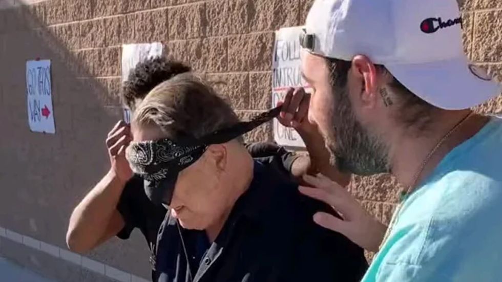 High school students remove bandana from blindfolded janitor