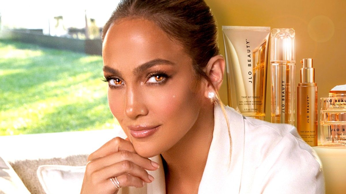 Jennifer Lopez smiling in front of her Jlo Beauty Sephora products