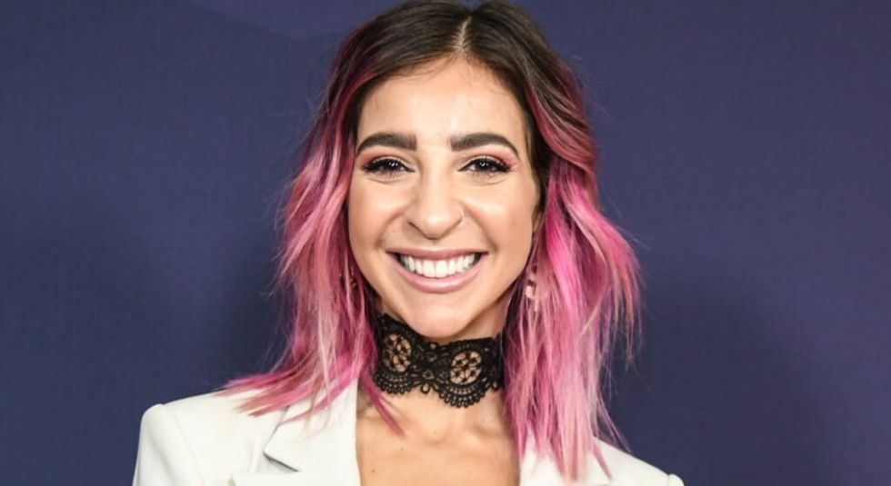 Gabbie Hanna with pink and brown hair smiling at the camera.