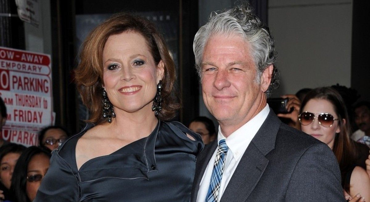 Sigourney Weaver in black dress with Jim Simpson wearing a black suit.