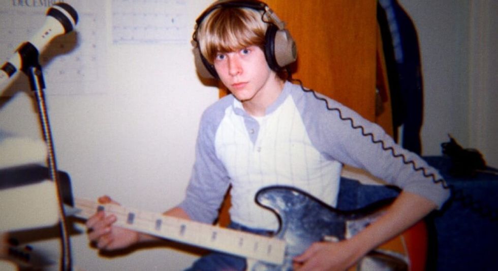 Image of a young Kurt Cobain playing the guitar.