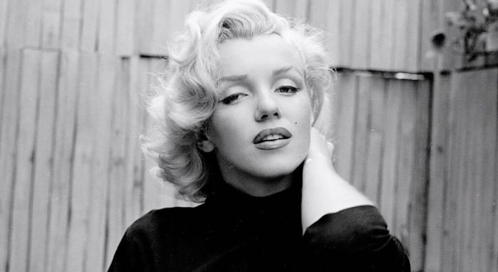 Marilyn Monroe black and white photo wearing black turtleneck.