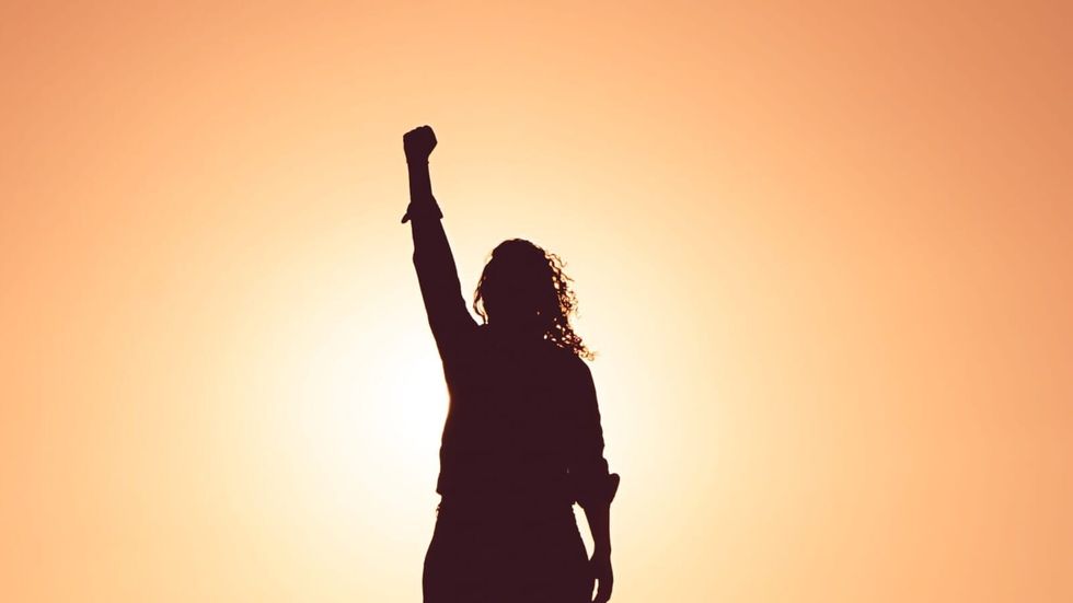 woman's silhouette raising her hand in a fist