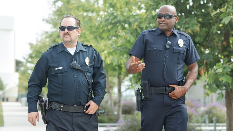 two police officers walking on the street 